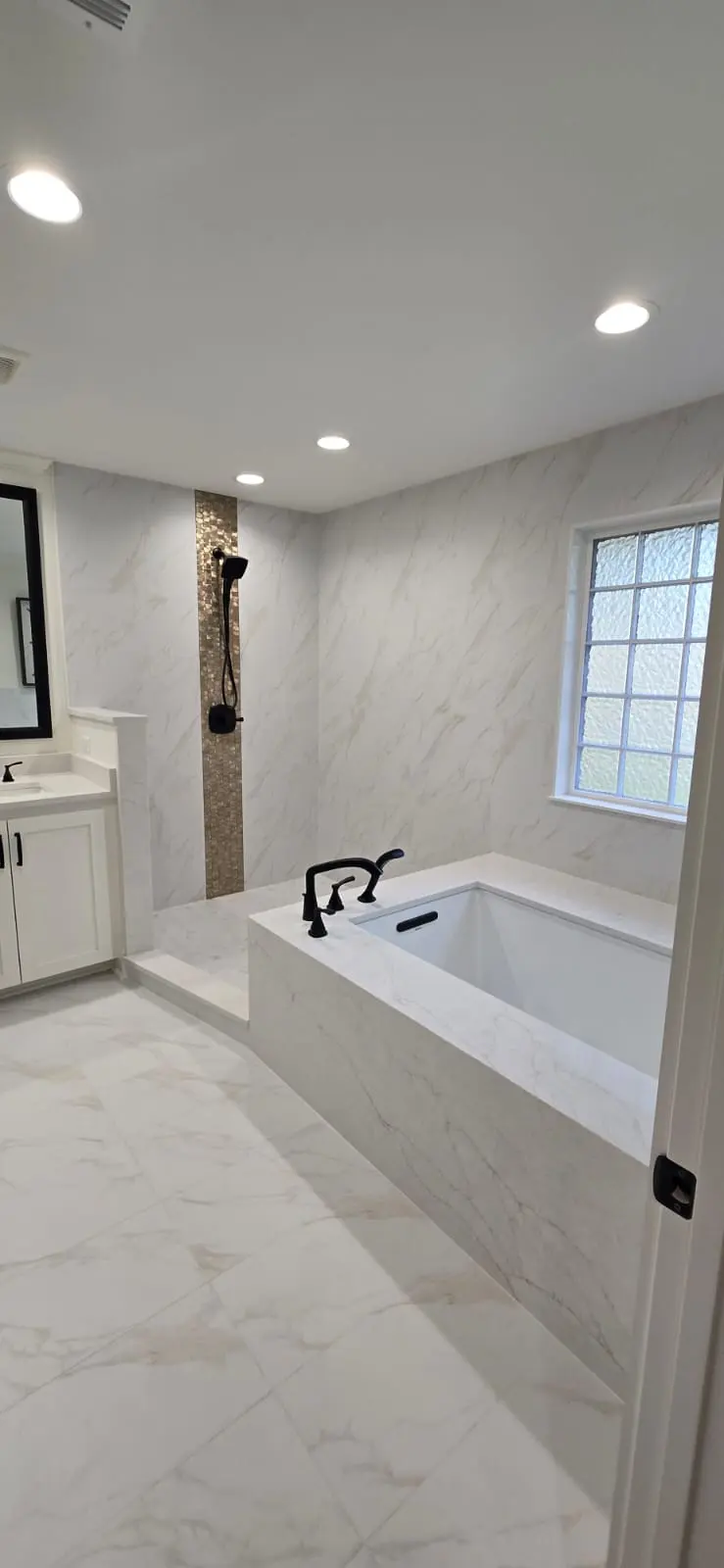 Marble-tile bathroom remodel with soaking tub and matte black fixtures in Hattiesburg, MS