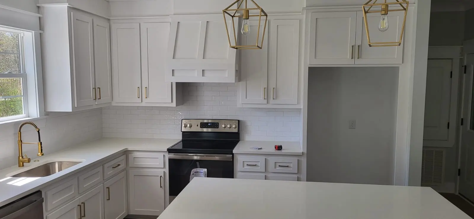 Custom kitchen cabinets with brass hardware and subway tile backsplash in Hattiesburg, MS