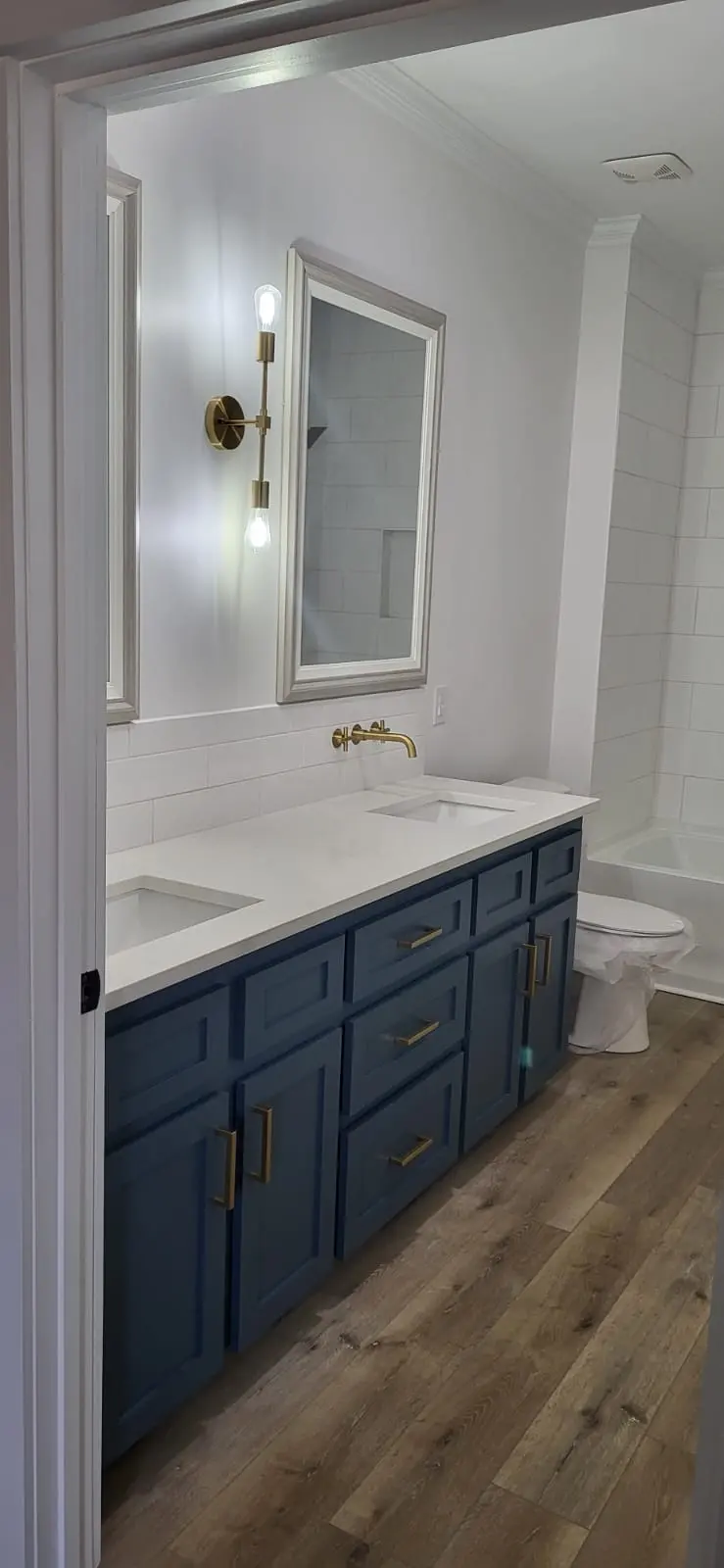 Custom navy blue bathroom vanity cabinets with brass fixtures in Hattiesburg, MS